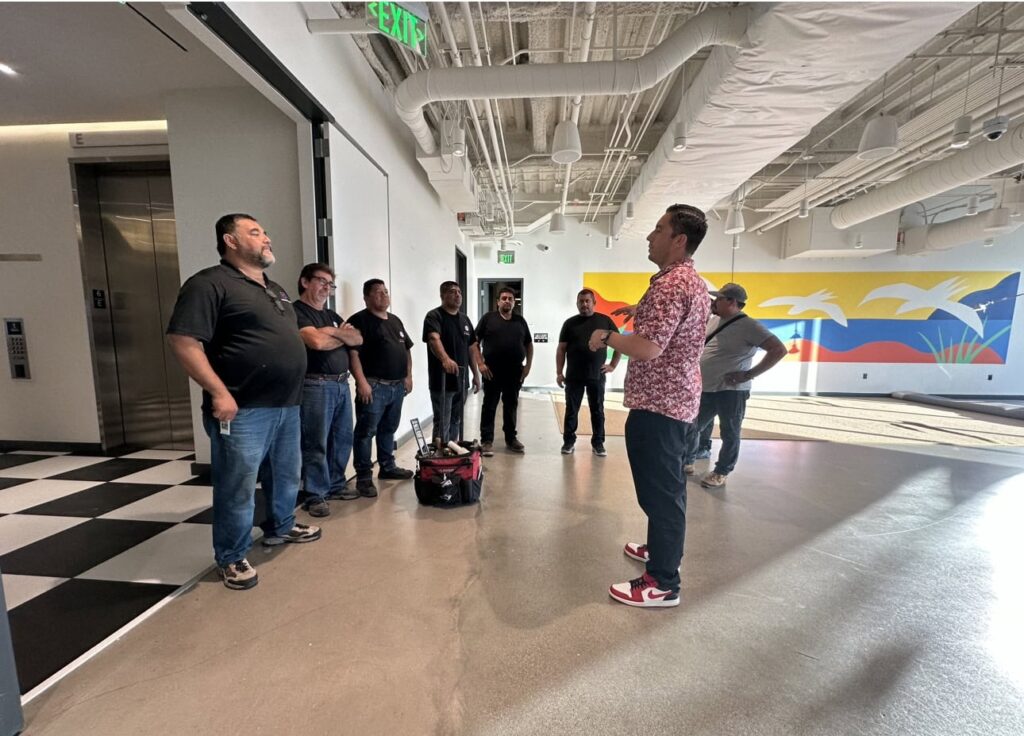Group of people receiving installation training in a modern indoor space.