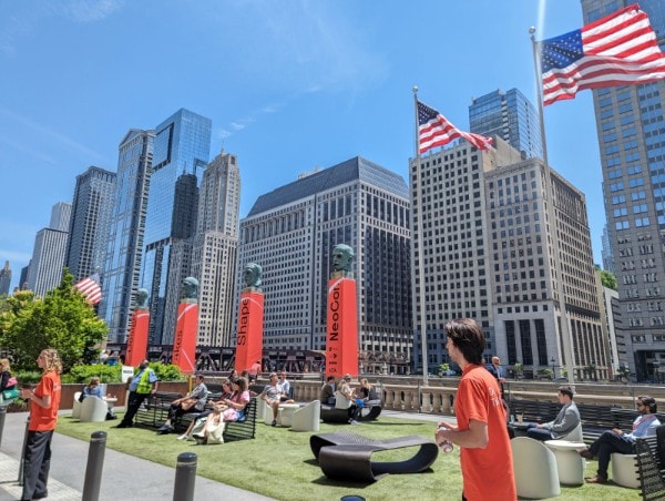 NeoCon 2024 cityscape with outdoor seating and American flags in Chicago.