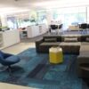 Contemporary office lounge with pre-owned cubicles and stylish furniture setup.