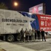 Cube World USA delivery truck with team in parking lot at night.
