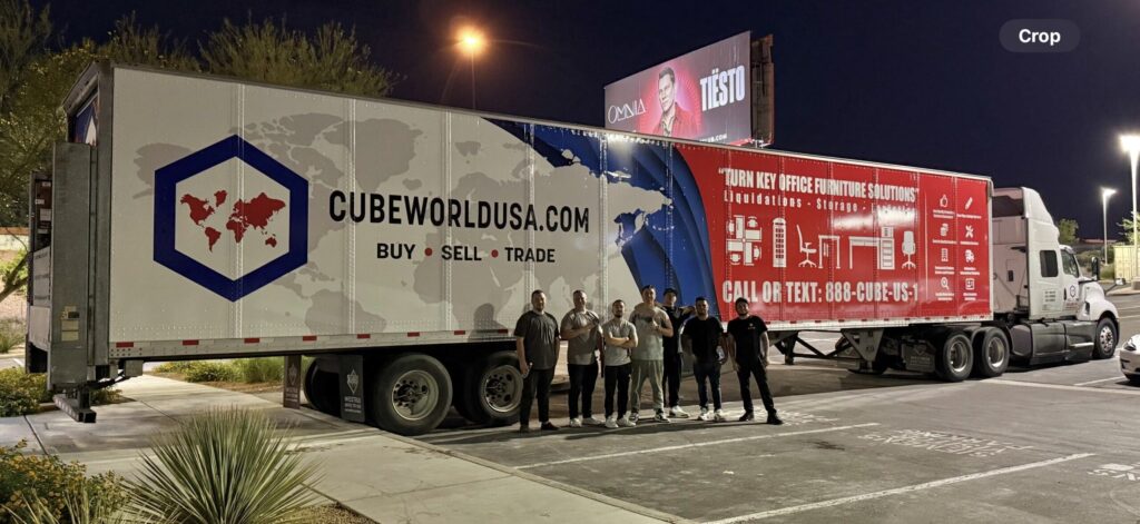 Cube World USA delivery truck with team in parking lot at night.